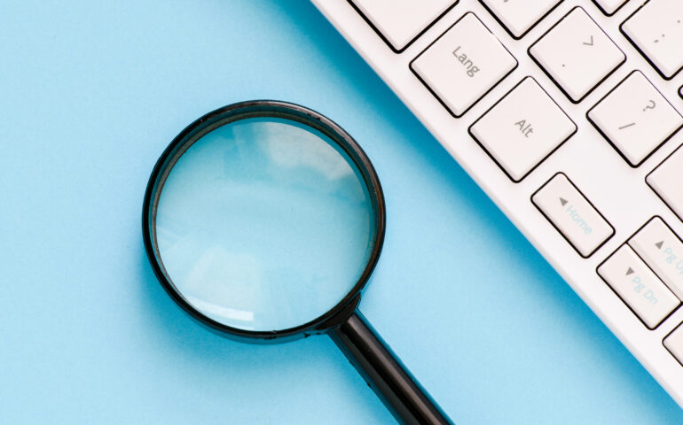 Moderation is like a magnifying glass laying beside computer keyboard on blue table